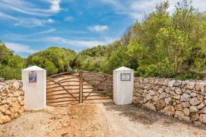 a stone fence and a bridge with a stone wall at Villa Mig Coster - Refugio rural en finca privada in Sant Lluis +24 photos