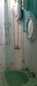 ein Badezimmer mit einem grünen Waschbecken und einem Spiegel in der Unterkunft Departamento 5p Tierra del Sol Eterno - Ica centro in Ica