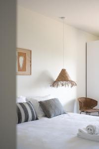 a bedroom with a white bed and a pendant light at Outsite Sagres - Work, Connect, Explore in Sagres +34 photos