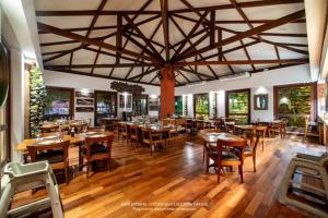 a restaurant with wooden tables and chairs and a large ceiling at Jatiúca Suítes Resort - Flat 413 in Maceió