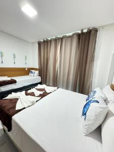 a room with two beds and a window at Pousada Tábua das Marés in Japaratinga