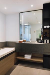 a bathroom with a tub and a large mirror at Domaine des Terres du Val in Wanze +11 photos