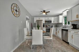 une cuisine avec une table et des chaises et une horloge au mur dans l'établissement Luxurious Retreat in Moncton, à Moncton 39 autres photos