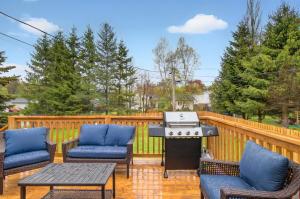 une terrasse avec 3 chaises et un grill sur une clôture dans l'établissement Luxurious Retreat in Moncton, à Moncton