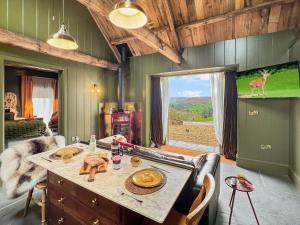 a dining room with a table and a deer on the wall at Buttercup Cottage in Treborough