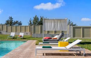 a pool with chairs and a couch next to a pool at Villa Traiani 8&2 by Marche Holiday Villas in Piagge