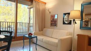 a living room with a white couch and a window at Hostdomus - Lumiere Apartment R15 in San Sicario +15 photos