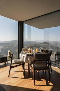 ein Esszimmer mit einem Tisch und Stühlen mit Aussicht in der Unterkunft Quinta Vale das Papas in Casal de Loivos