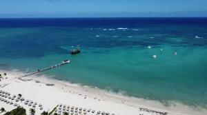an aerial view of a beach with a boat in the water at SUMMER DREAM STUDIOS DELUXE playa LOS CORALES in Punta Cana