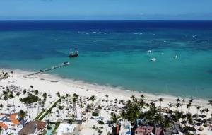 a view of a beach with a boat in the water at SUMMER DREAM STUDIOS DELUXE playa LOS CORALES in Punta Cana