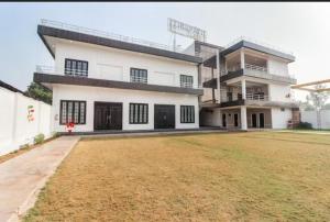 una gran casa blanca con un gran patio en Hotel Tirupati Lawn, en Lucknow