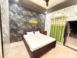 Un dormitorio con una cama en una habitación con una pared. en Hotel Tirupati Lawn, en Lucknow