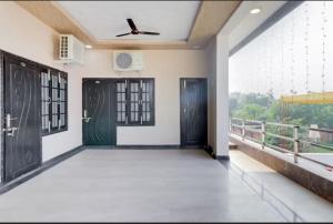 Habitación con 2 puertas y balcón. en Hotel Tirupati Lawn, en Lucknow