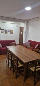 Una gran mesa de madera con sillas y un sofá rojo. en A Casa Di Luca, en Diamante 28 fotos más