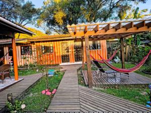 a wooden deck with a hammock and a house at Pousada Recanto das Cores in Ilha do Mel +81 photos