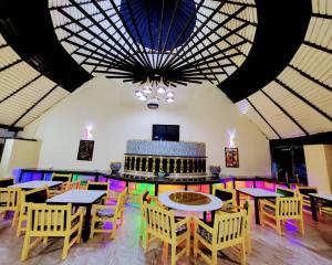 a dining room with tables and chairs and a large ceiling at Rusty Rock Beach Resort & Spa in Mwanza