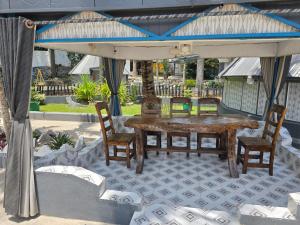 a table and chairs under an umbrella on a patio at Rusty Rock Beach Resort & Spa in Mwanza