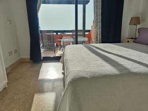 a bedroom with a bed and a large window at Ático de lujo con vistas al mar in Estepona +16 photos