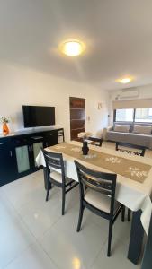 Un comedor con una mesa y sillas y una cama. en Edificio Manantiales, en Villa Carlos Paz