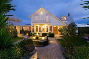 a large white house with a patio in front of it at Apollo Bay Guest House in Apollo Bay