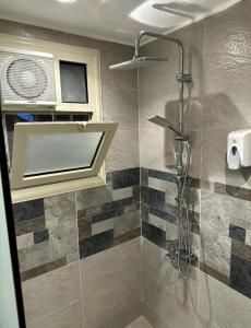 een badkamer met een douche met een glazen deur bij Lumora Pyramids InN in Caïro +34 foto's