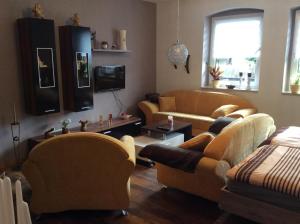 un salon avec deux canapés et une télévision dans l'établissement Ferienwohnung In Neustrelitz Mit Garten Und Grill, à Neustrelitz
