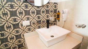 a bathroom with a white sink and a mirror at qema Mancora in Máncora