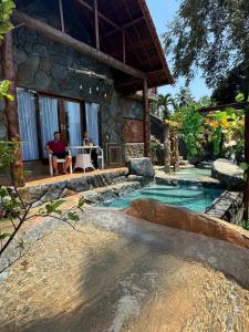 a couple sitting at a table in front of a house at Royal Kemani Unique Villa - Ubud Country Side in Bedahulu