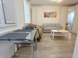 een woonkamer met een bank en een tafel bij le studio Rennequin in Parijs