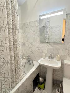 een badkamer met een wastafel en een douchegordijn bij le studio Rennequin in Parijs