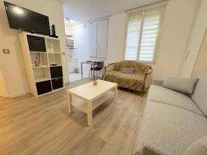 een woonkamer met een bank en een salontafel bij le studio Rennequin in Parijs