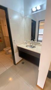 un baño con lavabo y espejo en Edificio Manantiales, en Villa Carlos Paz
