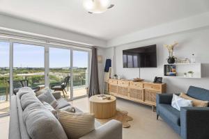 a living room with a couch and a tv at Eagle Beach-Best value-Island View 1BR condo-R362 in Palm-Eagle Beach
