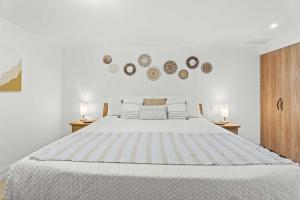 a white bedroom with a large bed with two lamps at Eagle Beach-Best value-Island View 1BR condo-R362 in Palm-Eagle Beach +57 photos