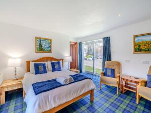 a bedroom with a large bed with blue pillows at Ben View in Aberlour