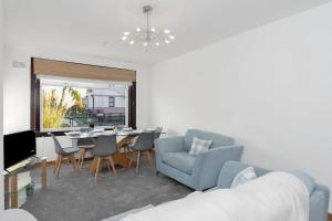 un salon avec un canapé bleu et une table dans l'établissement Free Parking - Central - Sleeps 6 - 3 Bedrooms, à Tranent