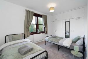 une chambre avec deux lits et une fenêtre dans l'établissement Free Parking - Central - Sleeps 6 - 3 Bedrooms, à Tranent