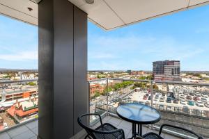 a balcony with a table and chairs and a view of a city at Adelaide Central Skyline Panoramic Suite Two in Adelaide