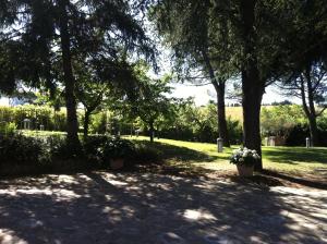 um parque com árvores e flores à sombra em Villa Nunzia em Cupramontana