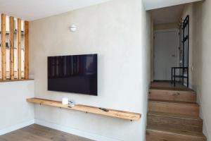 ein Wohnzimmer mit einem Flachbildfernseher an der Wand in der Unterkunft Modern Chatham home with garden retreat in Chatham