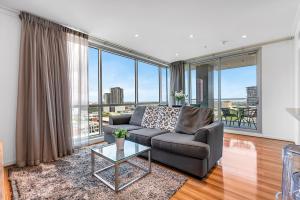 a living room with a couch and large windows at Adelaide Central Skyline Panoramic Suite Two in Adelaide +22 photos