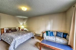 een slaapkamer met een bed en een bank bij Bogus Basin Comfort -226 D in Bogus Basin