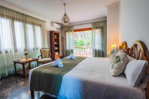 una camera da letto con un letto grande e una sedia di Villa Damar a Can Picafort Altre 35 foto