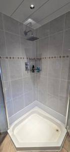 Un baño con ducha con bañera blanca. en Malina at The Green, en Glasgow