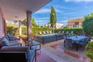 un patio con divani, tavoli e sedie di Villa Damar a Can Picafort