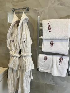 un grupo de toallas colgando de un toallero en el baño en SEAR Ailəvi Məkan, en Qusar