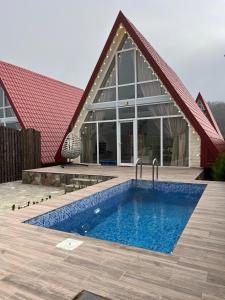 una casa con piscina delante de un edificio en SEAR Ailəvi Məkan, en Qusar