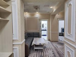 een woonkamer met een bank en een tafel bij Gold 99 in Samarkand