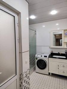 een badkamer met een wasmachine en een wastafel bij Gold 99 in Samarkand