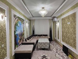 een woonkamer met banken en een kroonluchter bij Gold 99 in Samarkand